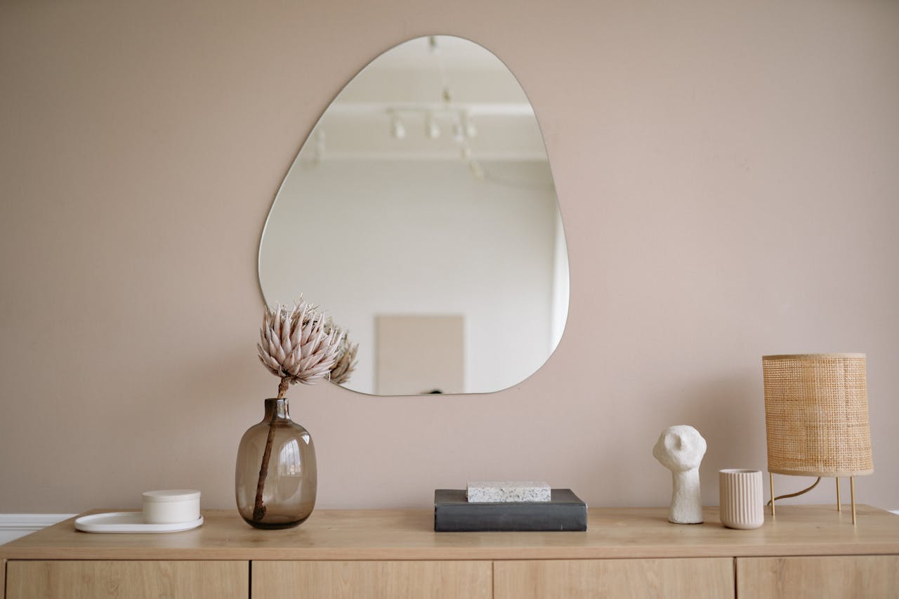 our-experience Stylish minimalist interior featuring a mirror, decorative vase, and lamp.